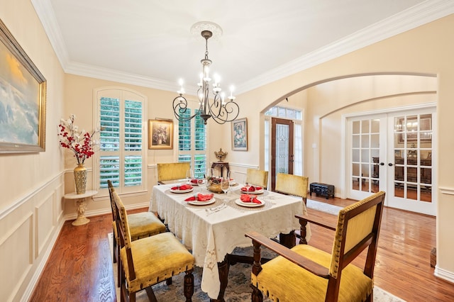 16018 Lower Lake Dr, Cypress, TX 77433 - dining room with french doors, arched walkways, wood finished floors, crown molding, and a chandelier