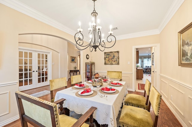 16018 Lower Lake Dr, Cypress, TX 77433 - dining space with french doors, ornamental molding, a chandelier, arched walkways, and a wainscoted wall