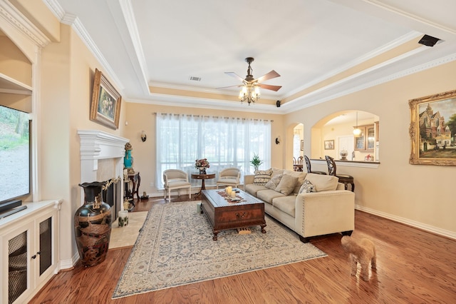 16018 Lower Lake Dr, Cypress, TX 77433 - living area featuring a fireplace with flush hearth, crown molding, a tray ceiling, and healthy amount of natural light