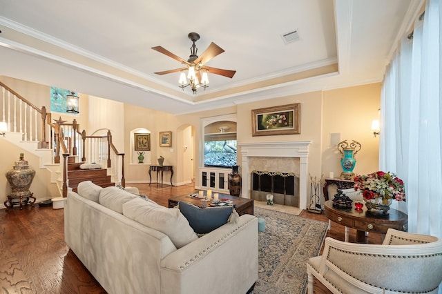 16018 Lower Lake Dr, Cypress, TX 77433 - living room with arched walkways, a tray ceiling, crown molding, stairway, and a ceiling fan
