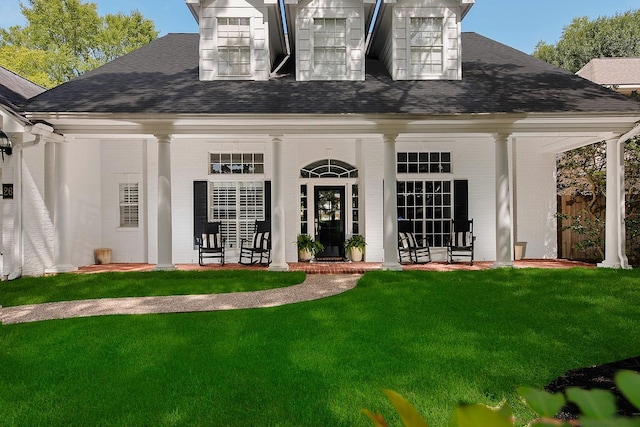 26 W Fairbranch Cir, The Woodlands, TX 77382 - back of property featuring covered porch, a yard, a shingled roof, and brick siding