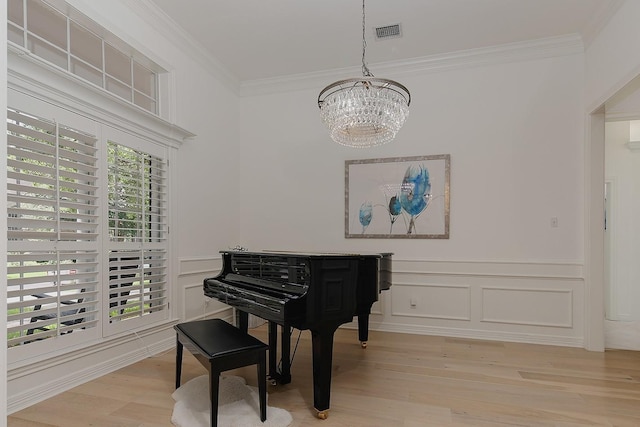 26 W Fairbranch Cir, The Woodlands, TX 77382 - living area with a chandelier, crown molding, light wood-style floors, wainscoting, and a decorative wall