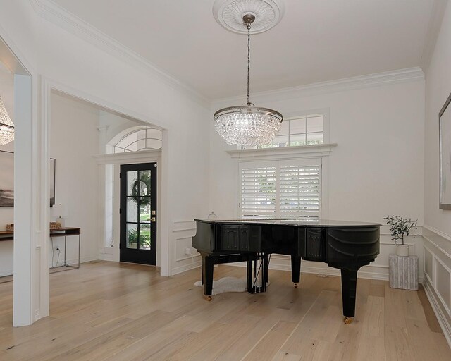 26 W Fairbranch Cir, The Woodlands, TX 77382 - foyer with ornamental molding, a chandelier, light wood-style floors, and a decorative wall