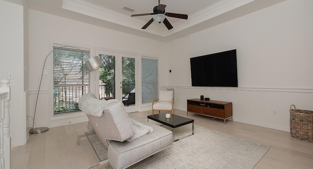26 W Fairbranch Cir, The Woodlands, TX 77382 - living area with light wood finished floors, crown molding, wainscoting, a ceiling fan, and a tray ceiling