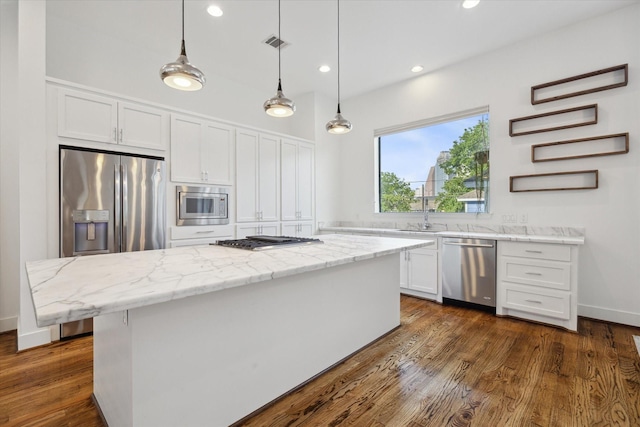 1408 Ruthven St, Houston, TX 77019 - kitchen featuring appliances with stainless steel finishes, white cabinets, light stone counters, pendant lighting, and recessed lighting