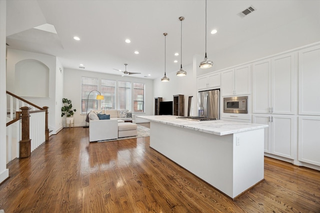 1408 Ruthven St, Houston, TX 77019 - kitchen featuring stainless steel appliances, white cabinetry, a center island, light stone counters, and hanging light fixtures