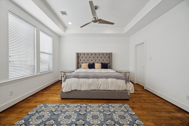 1408 Ruthven St, Houston, TX 77019 - bedroom featuring wood finished floors, a raised ceiling, and a ceiling fan