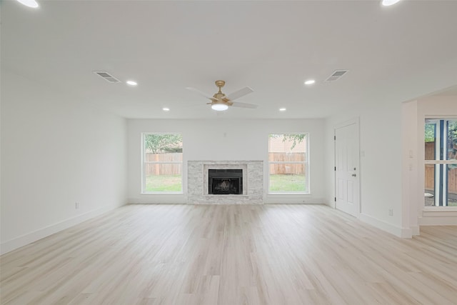 17802 Poppy Trails Ln, Houston, TX 77084 - unfurnished living room featuring light wood-style flooring, a ceiling fan, a stone fireplace, and recessed lighting