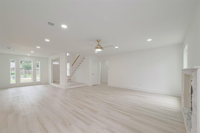 17802 Poppy Trails Ln, Houston, TX 77084 - unfurnished living room with stairs, a premium fireplace, recessed lighting, light wood-type flooring, and a ceiling fan