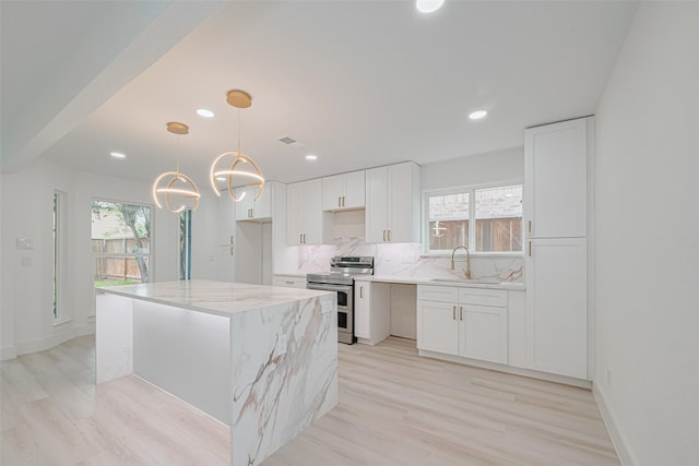 17802 Poppy Trails Ln, Houston, TX 77084 - kitchen featuring double oven range, plenty of natural light, light stone countertops, white cabinets, and recessed lighting