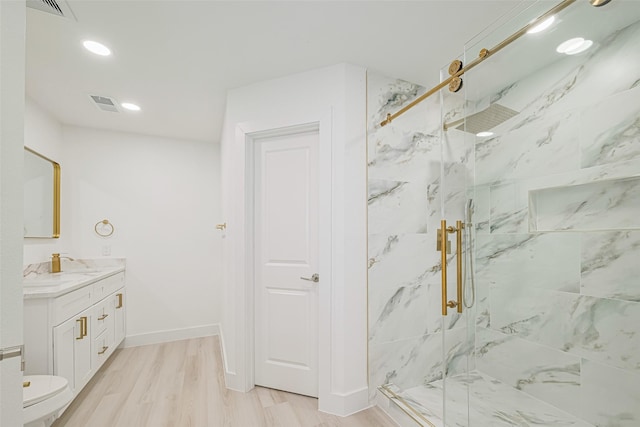 17802 Poppy Trails Ln, Houston, TX 77084 - bathroom featuring vanity, a marble finish shower, wood finished floors, and recessed lighting