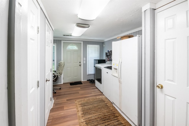 24917 W Christine Dr, Splendora, TX 77372 - kitchen with washing machine and clothes dryer, white fridge with ice dispenser, light wood-style flooring, white cabinetry, and light countertops