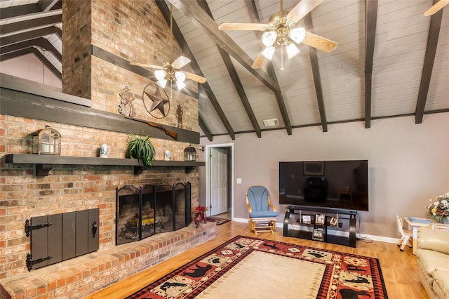 24917 W Christine Dr, Splendora, TX 77372 - living area with wood finished floors, a ceiling fan, a brick fireplace, a wooden ceiling with exposed beams, and high vaulted ceiling