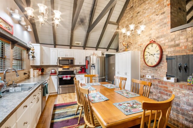 24917 W Christine Dr, Splendora, TX 77372 - dining area featuring a chandelier, light wood finished floors, high vaulted ceiling, and a wood ceiling with exposed beams