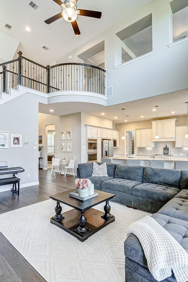 28606 Royal Pines Ct, Fulshear, TX 77441 - living area with ceiling fan, dark wood-style floors, a towering ceiling, and stairs