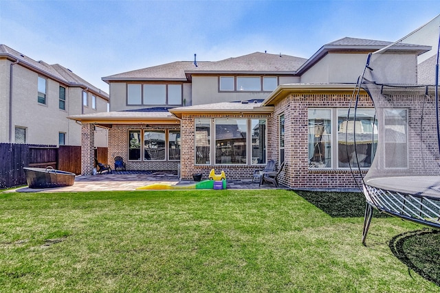 28606 Royal Pines Ct, Fulshear, TX 77441 - back of property featuring brick siding, a patio area, roof with shingles, and a trampoline