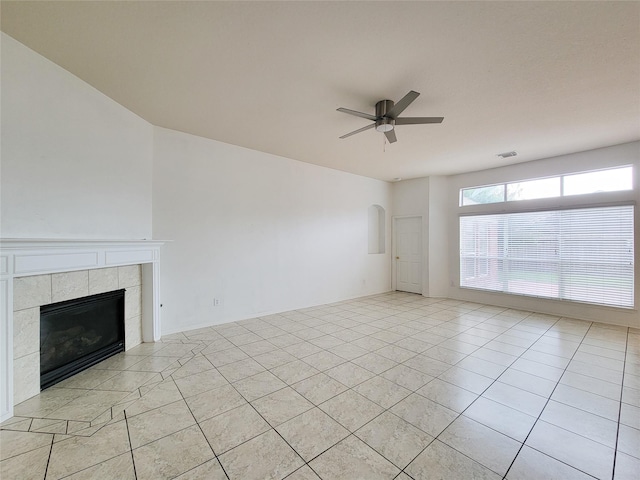 15311 Streetcar Ct, Cypress, TX 77429 - unfurnished living room with a ceiling fan, a tile fireplace, light tile patterned floors, and arched walkways