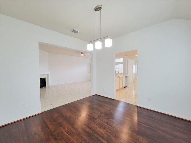 15311 Streetcar Ct, Cypress, TX 77429 - empty room featuring light wood-type flooring, a ceiling fan, a fireplace, and vaulted ceiling