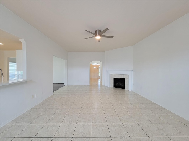 15311 Streetcar Ct, Cypress, TX 77429 - unfurnished living room featuring ceiling fan, arched walkways, and a tiled fireplace
