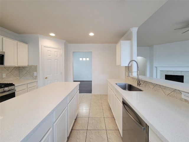 15311 Streetcar Ct, Cypress, TX 77429 - kitchen with appliances with stainless steel finishes, backsplash, white cabinetry, recessed lighting, and a tile fireplace