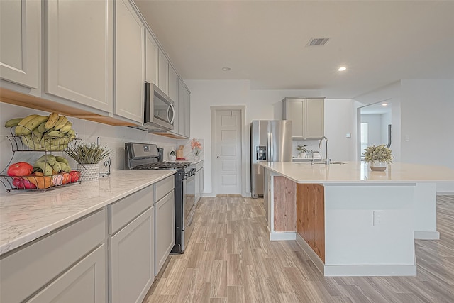 1815 Sandy Trail Ln, Rosenberg, TX 77469 - kitchen with appliances with stainless steel finishes, light wood-style floors, backsplash, an island with sink, and recessed lighting