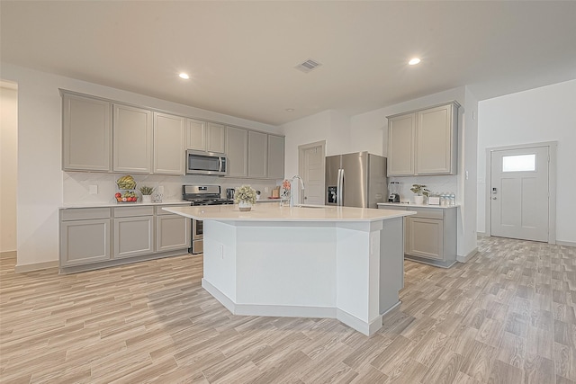 1815 Sandy Trail Ln, Rosenberg, TX 77469 - kitchen featuring appliances with stainless steel finishes, gray cabinetry, light wood-style flooring, decorative backsplash, and recessed lighting