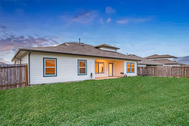 1815 Sandy Trail Ln, Rosenberg, TX 77469 - back of house at dusk with a fenced backyard and a patio