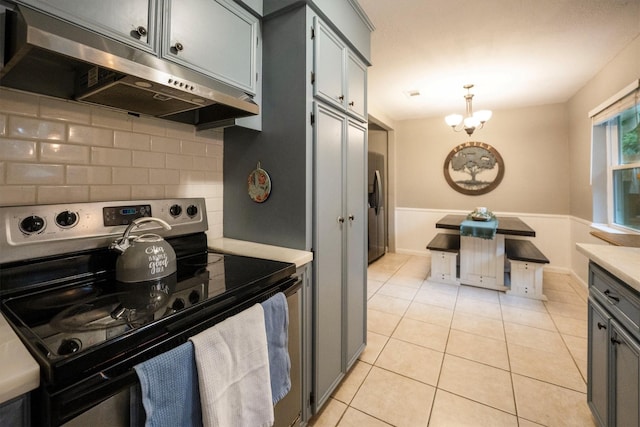 15638 Charolais Dr, Cypress, TX 77429 - kitchen with appliances with stainless steel finishes, range hood, tasteful backsplash, light countertops, and a chandelier