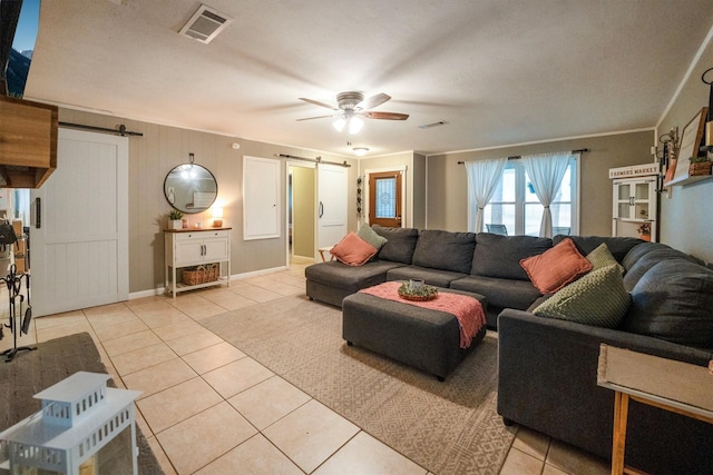 15638 Charolais Dr, Cypress, TX 77429 - living area with a barn door, light tile patterned flooring, a ceiling fan, and ornamental molding