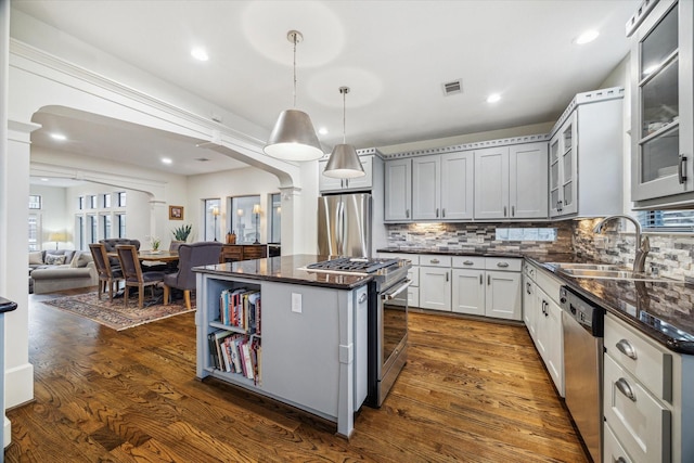 6410 Rodrigo St Unit B, Houston, TX 77007 - kitchen with appliances with stainless steel finishes, decorative columns, dark wood-style floors, a kitchen island, and backsplash