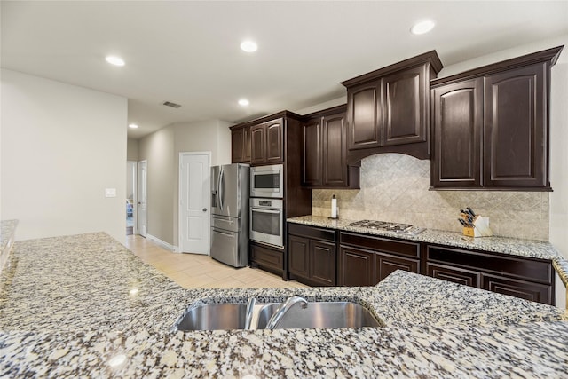 3834 Trophy Ridge Dr, Spring, TX 77386 - kitchen featuring appliances with stainless steel finishes, decorative backsplash, dark brown cabinets, light wood-type flooring, and recessed lighting