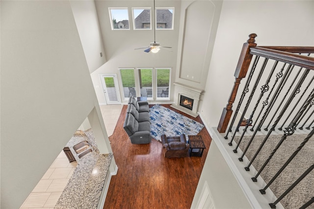 3834 Trophy Ridge Dr, Spring, TX 77386 - living area featuring a towering ceiling, a fireplace with flush hearth, wood finished floors, and a ceiling fan