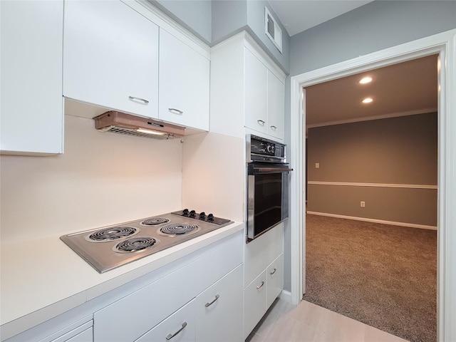 2600 Bellefontaine St Unit A21, Houston, TX 77025 - kitchen featuring oven, stainless steel electric stovetop, light countertops, white cabinets, and ventilation hood