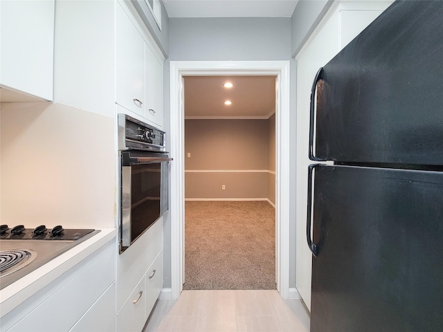 2600 Bellefontaine St Unit A21, Houston, TX 77025 - kitchen with black appliances, white cabinets, light countertops, light colored carpet, and recessed lighting