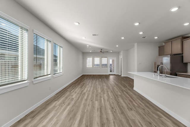 21521 Witham Promenade Ln, Magnolia, TX 77355 - unfurnished living room with recessed lighting, light wood finished floors, and a ceiling fan