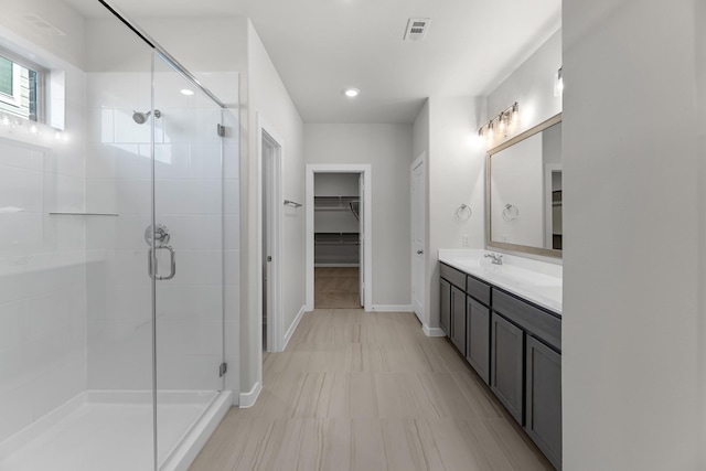 21521 Witham Promenade Ln, Magnolia, TX 77355 - bathroom featuring a shower stall, double vanity, a walk in closet, and recessed lighting