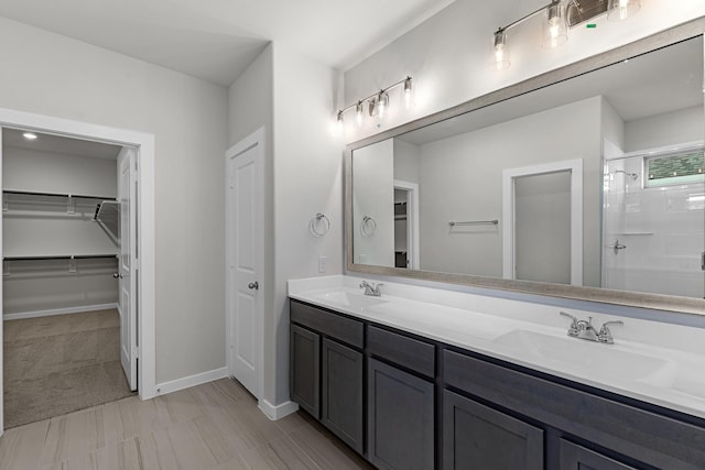 21521 Witham Promenade Ln, Magnolia, TX 77355 - bathroom with a walk in closet, double vanity, and a shower stall