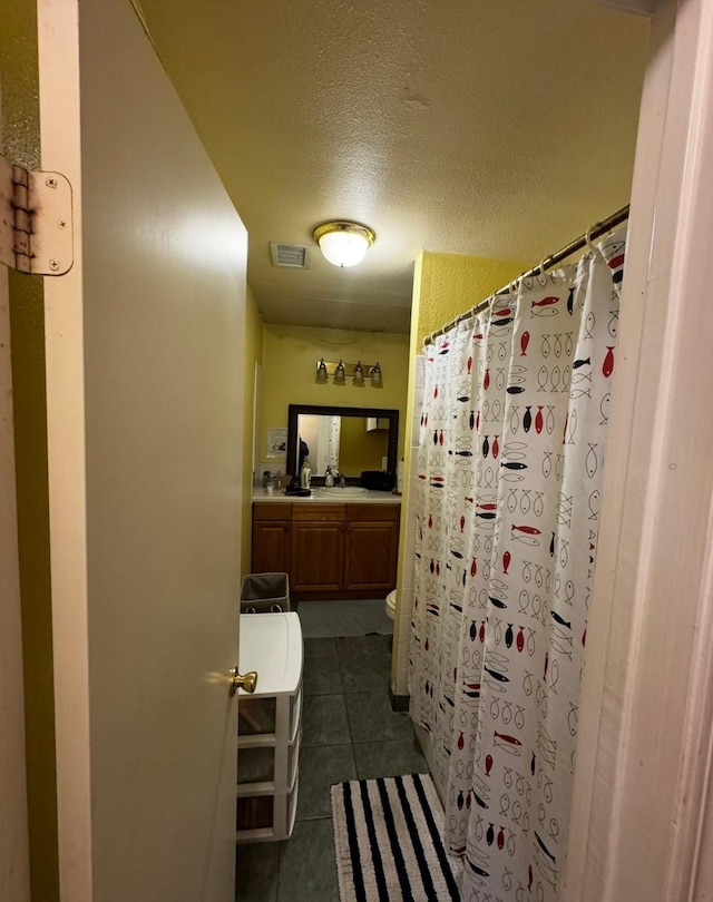 3201 Stallings Dr, Houston, TX 77088 - full bathroom featuring vanity, tile patterned flooring, a textured ceiling, and a shower with shower curtain