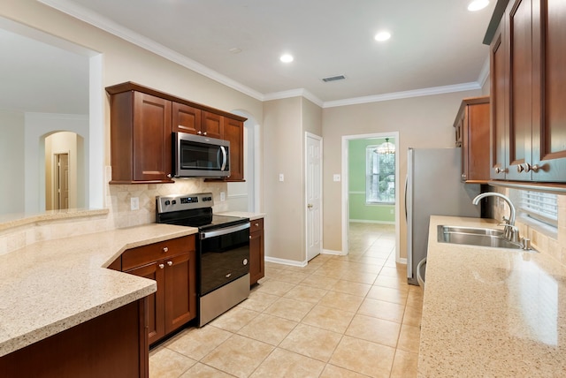 31 N Winterport Cir, The Woodlands, TX 77382 - kitchen featuring appliances with stainless steel finishes, crown molding, decorative backsplash, arched walkways, and light stone countertops