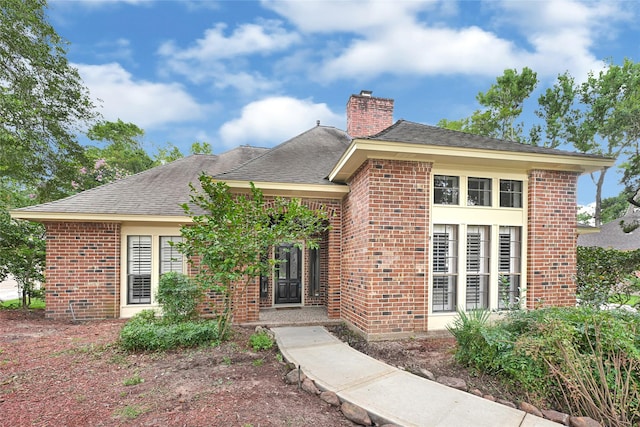 2814 Rustic Woods Dr, Houston, TX 77345 - view of front of home featuring brick siding, a chimney, and roof with shingles