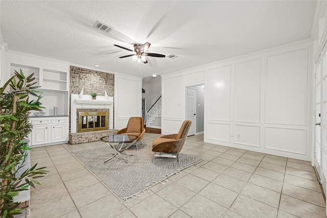 2814 Rustic Woods Dr, Houston, TX 77345 - sitting room with a decorative wall, a fireplace, ceiling fan, light tile patterned floors, and built in shelves