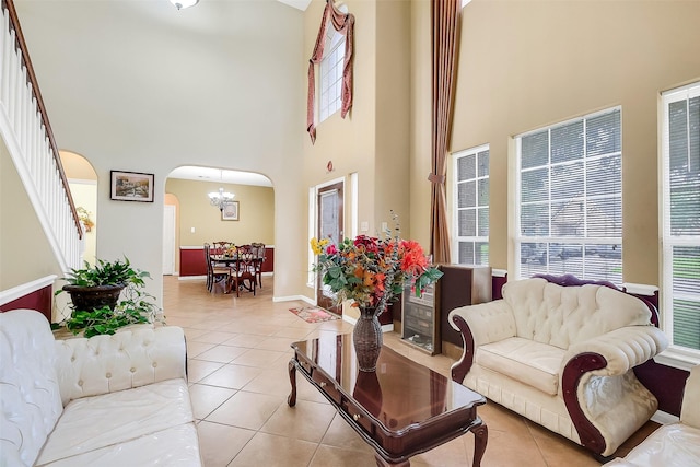 3705 Canterbury Park Dr, Pearland, TX 77584 - living room with a towering ceiling, arched walkways, light tile patterned flooring, and stairway