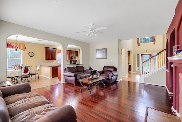 3705 Canterbury Park Dr, Pearland, TX 77584 - living room with arched walkways, light wood-style floors, ceiling fan, and stairs