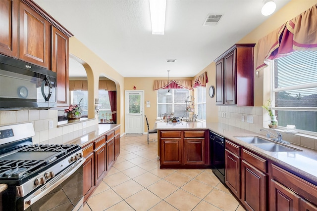 3705 Canterbury Park Dr, Pearland, TX 77584 - kitchen with black appliances, a peninsula, backsplash, and light countertops