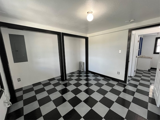 6625 Morris, Galveston, TX 77551 - unfurnished bedroom featuring electric panel, dark flooring, a closet, and a textured ceiling
