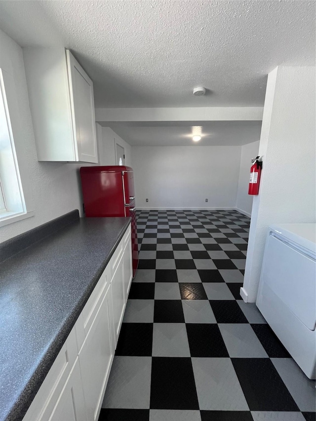 6625 Morris, Galveston, TX 77551 - kitchen featuring dark floors, white cabinetry, dark countertops, and a textured ceiling