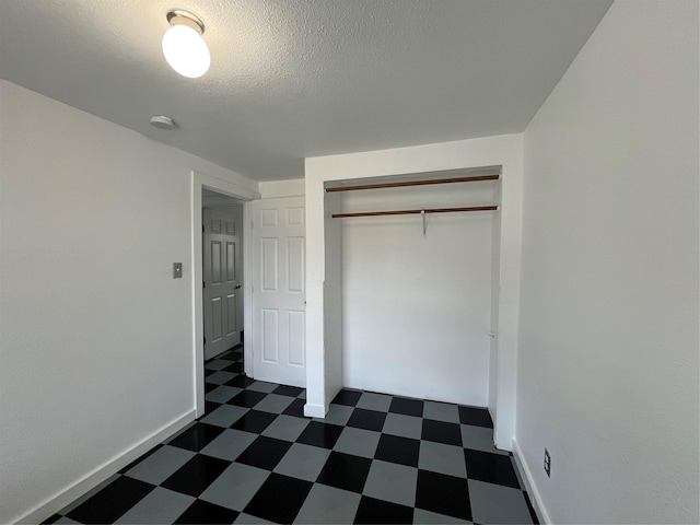 6625 Morris, Galveston, TX 77551 - unfurnished bedroom featuring dark flooring, a closet, and a textured ceiling