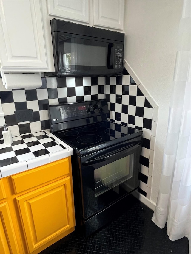 6625 Morris, Galveston, TX 77551 - kitchen featuring black appliances, tile counters, white cabinetry, and decorative backsplash