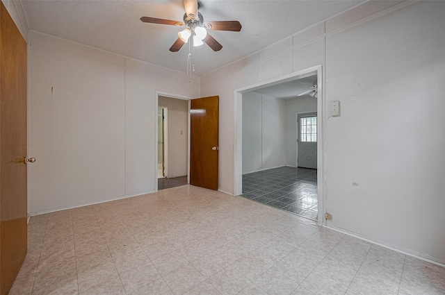 512 Threlkeld St, Houston, TX 77007 - empty room with a ceiling fan, a textured ceiling, ornamental molding, and tile patterned floors