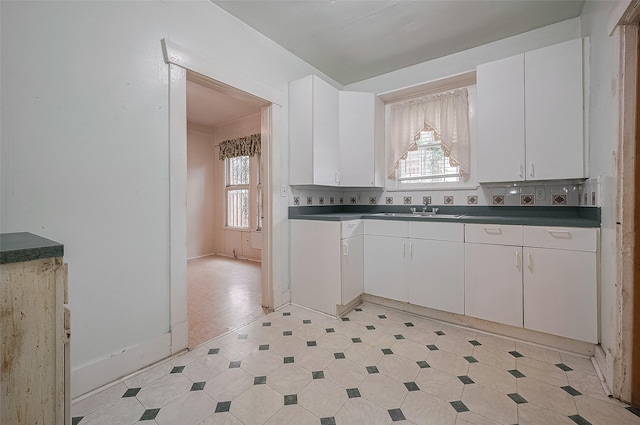 512 Threlkeld St, Houston, TX 77007 - kitchen featuring healthy amount of natural light, white cabinetry, light floors, and dark countertops